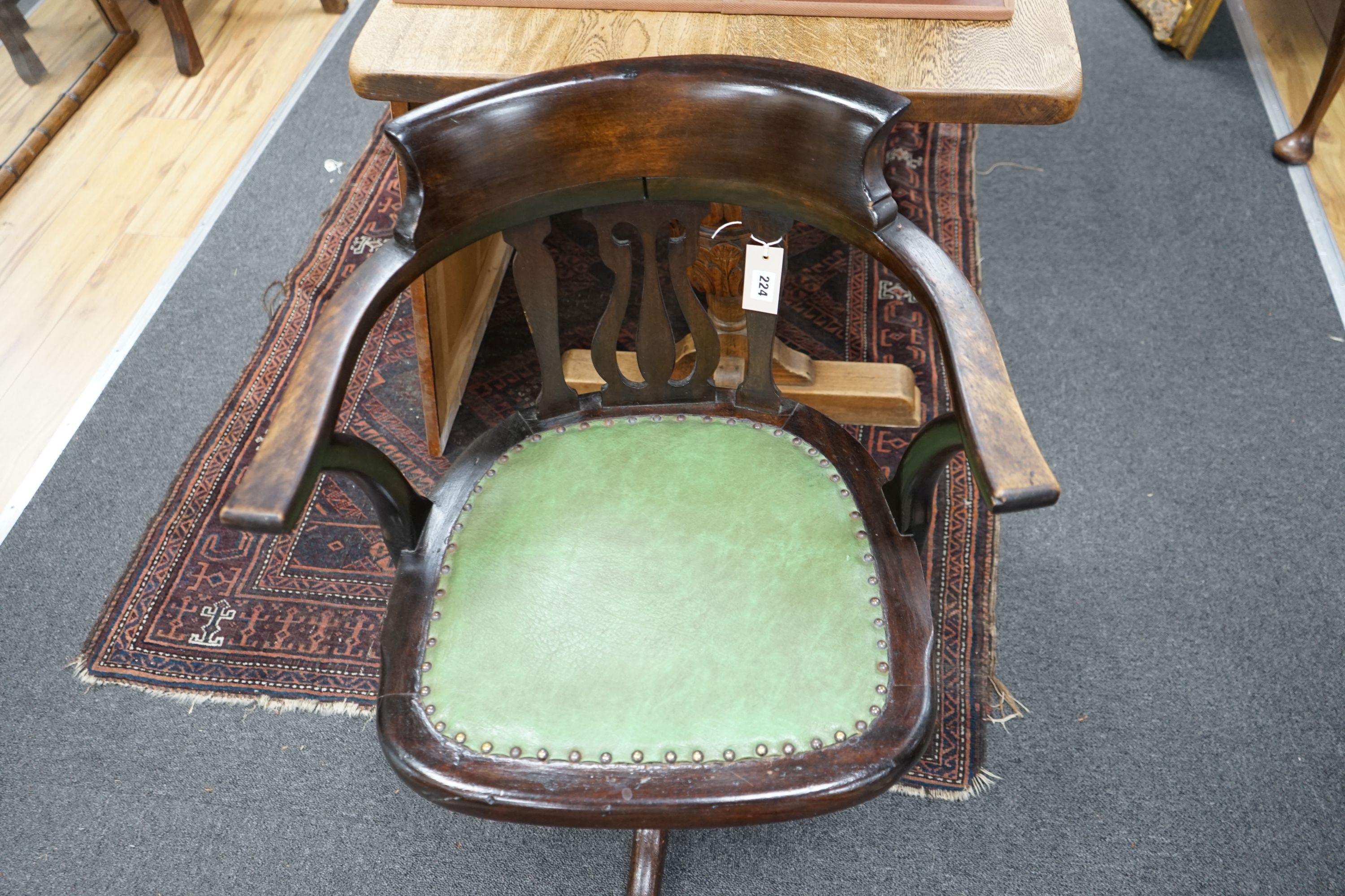 An Edwardian beech revolving office elbow chair